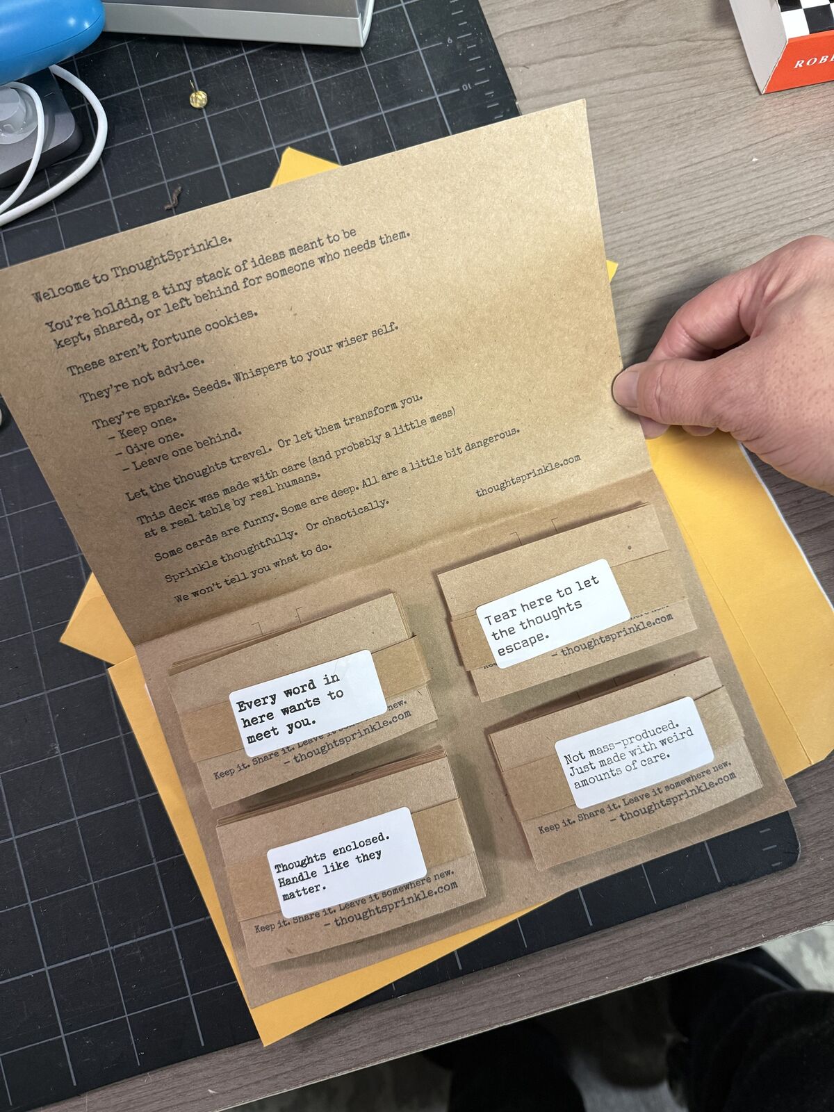 An opened kraft folder of banded card stacks on a cutting mat
