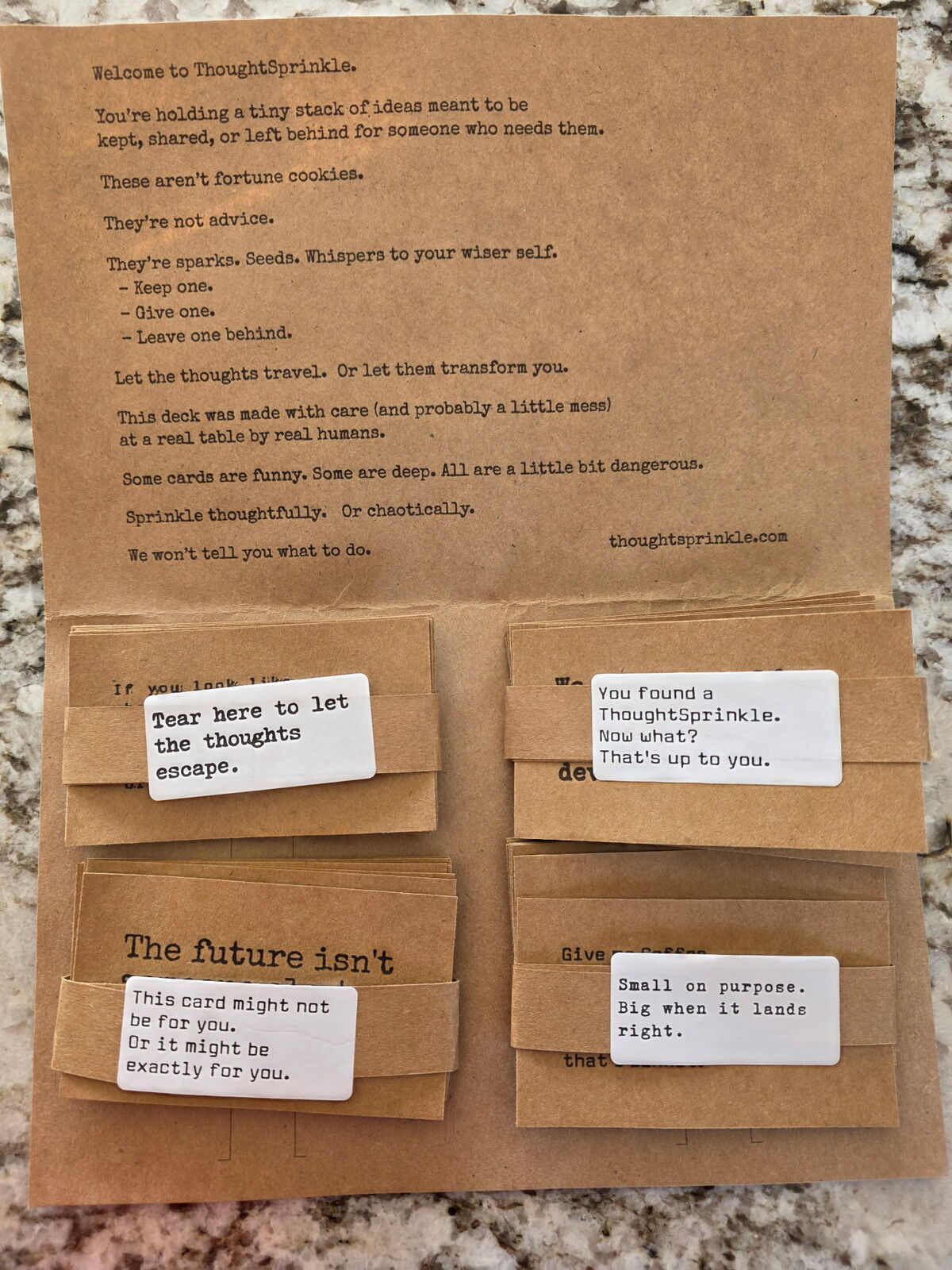 A kraft folder lying open: a typewritten welcome letter above four banded stacks of cards